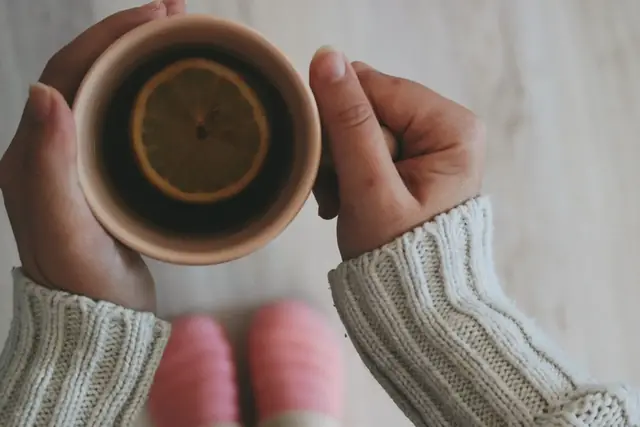 Limonlu sıcak çay fincanını iki eliyle tutan kişi; kaygı ile baş etme yolları