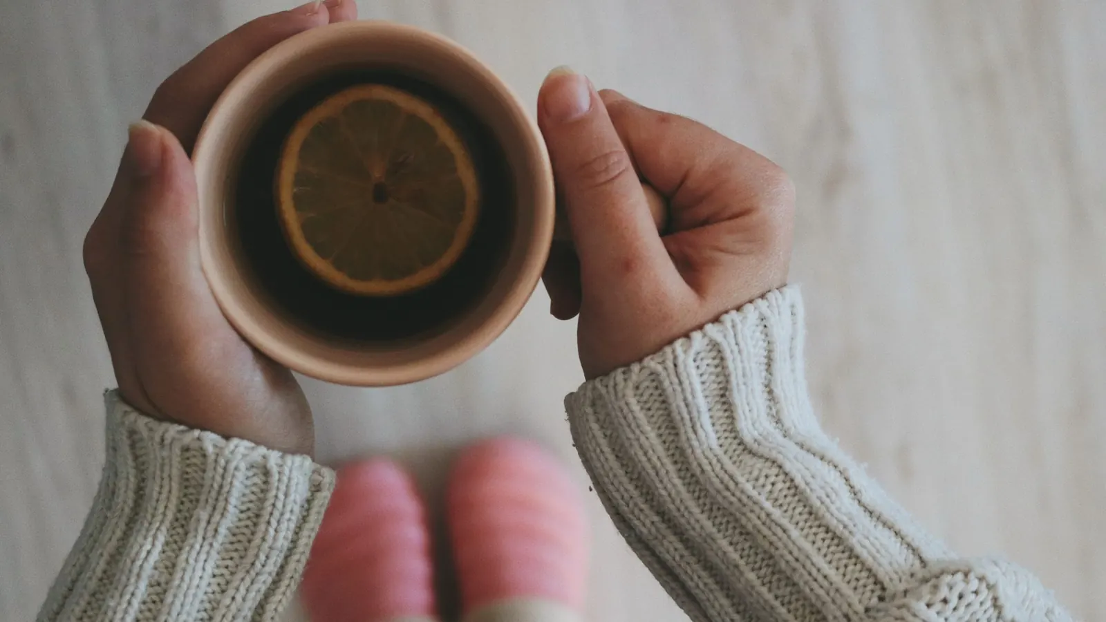 Limonlu sıcak çay fincanını iki eliyle tutan kişi; kaygı ile baş etme yolları